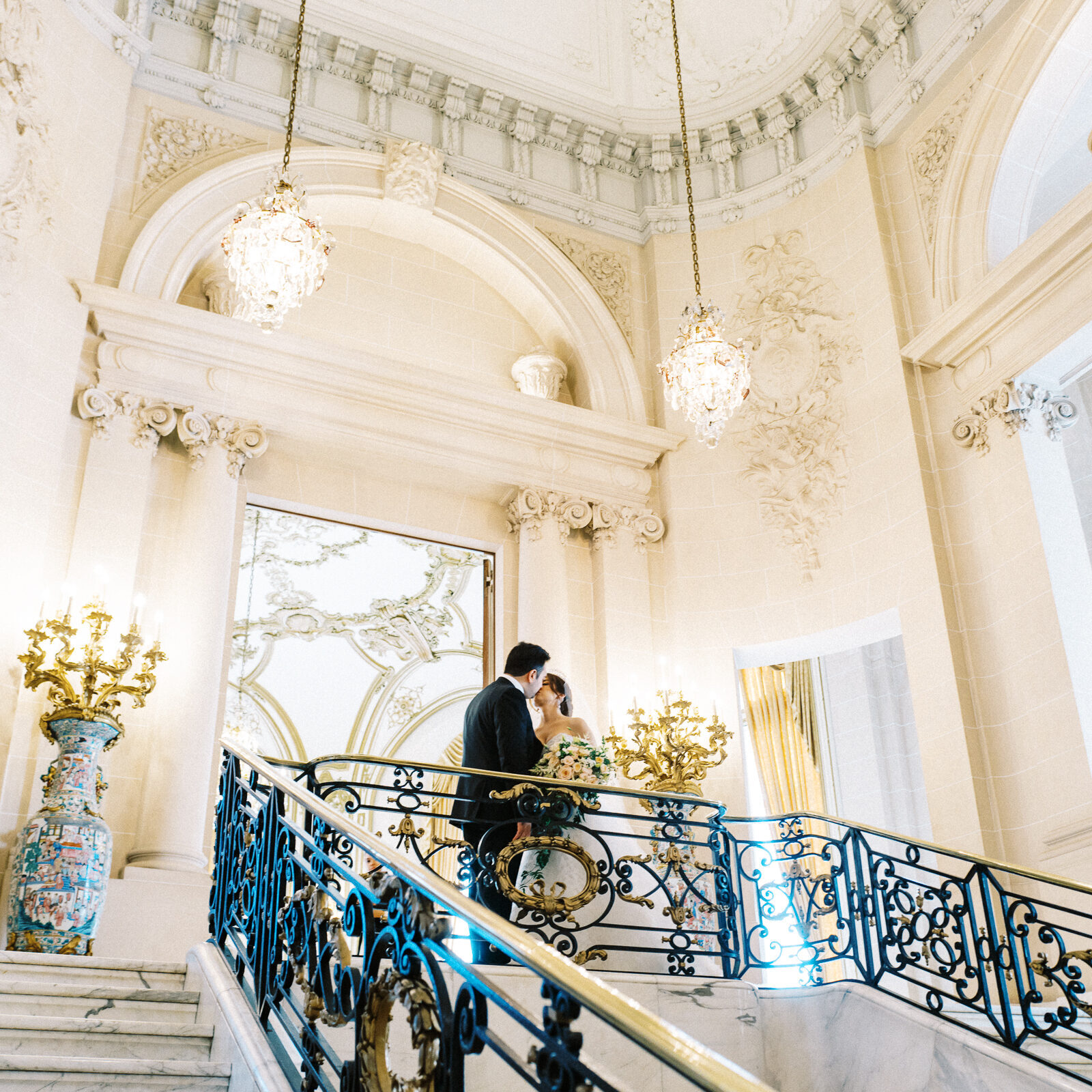 A couple stands on the steps of the Perry Belmont House in Washington DC