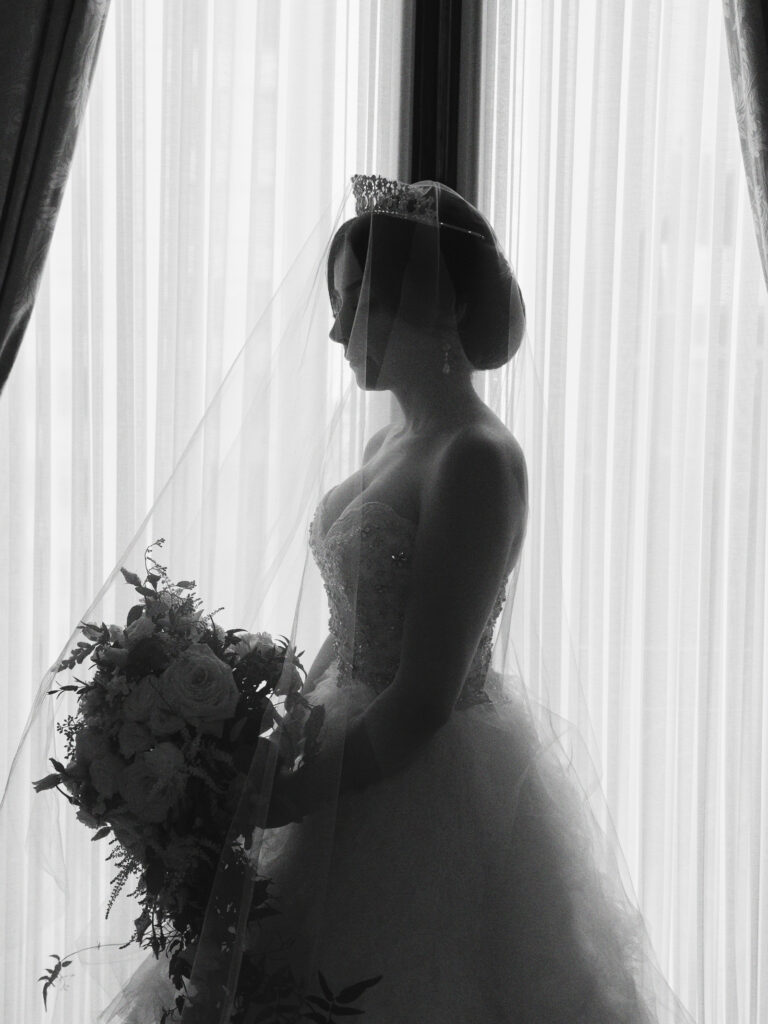 A bride stands in the window of the Perry Belmont House