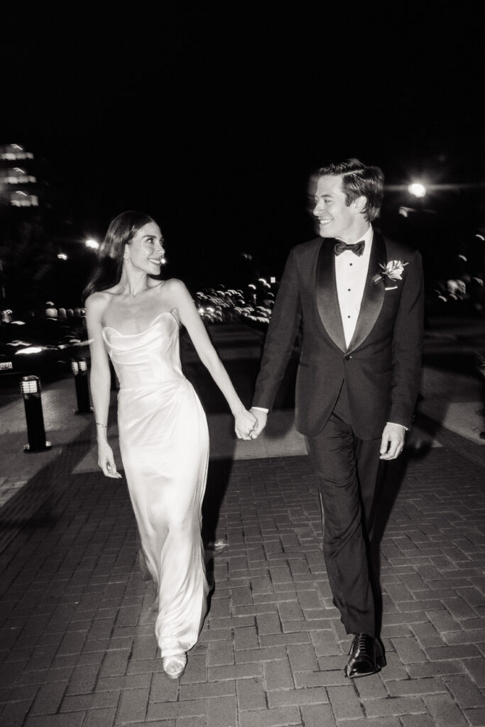 A wedding couple walks down the street in front of the St. Regis Hotel in Washington, DC