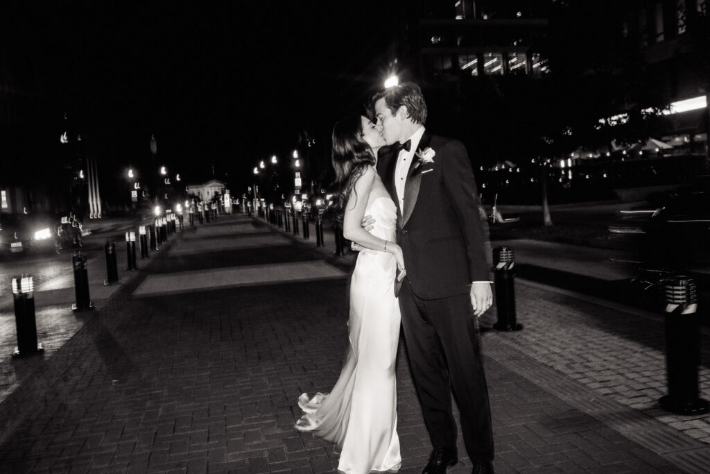 A wedding couple kisses in front of the St. Regis Hotel in Washington, DC