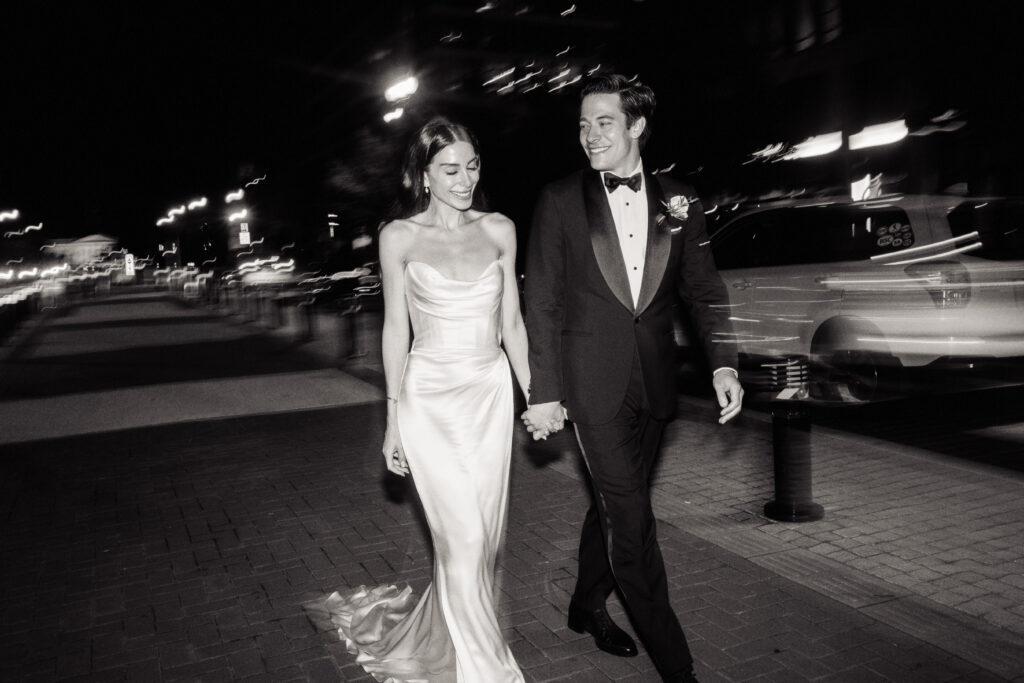 A newlywed couple walks down the street in front of the St. Regis Hotel in Washington, DC