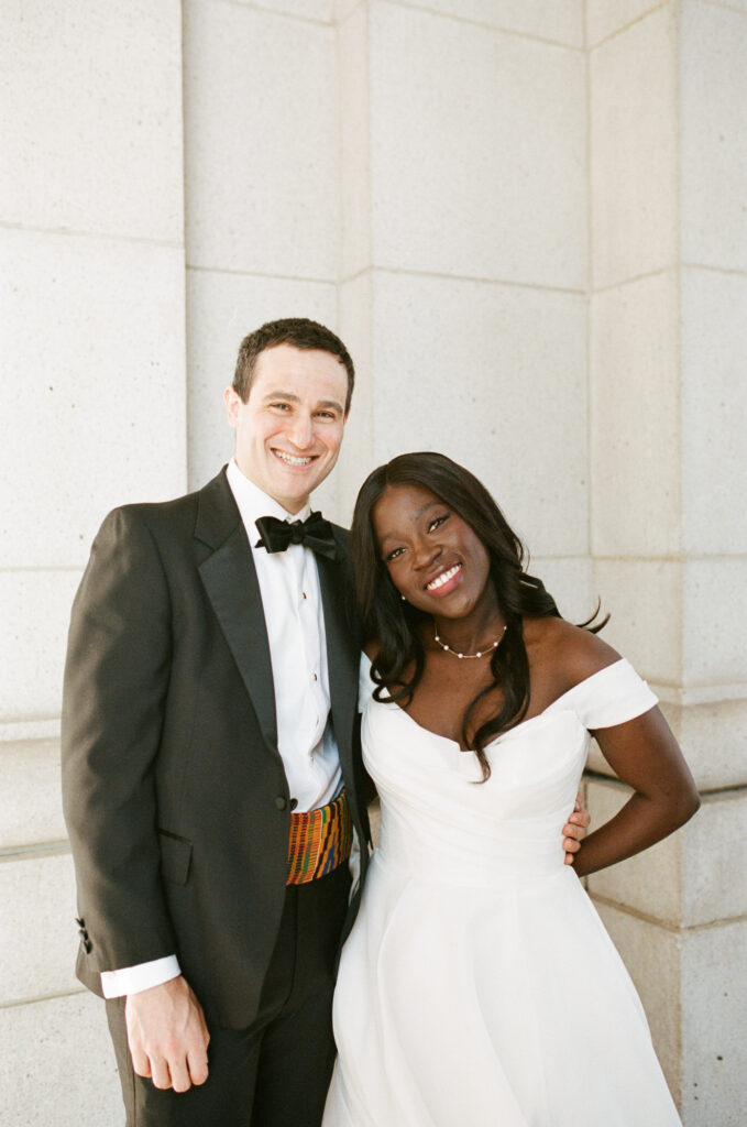 A Union Station wedding couple poses in front of their ceremony in Washington DC